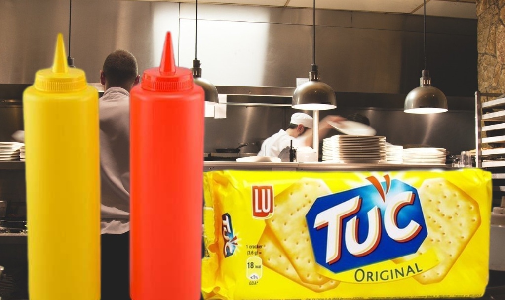 paquet de Tuc avec des bouteilles de moutarde et de ketchup dans une cuisine de restaurant